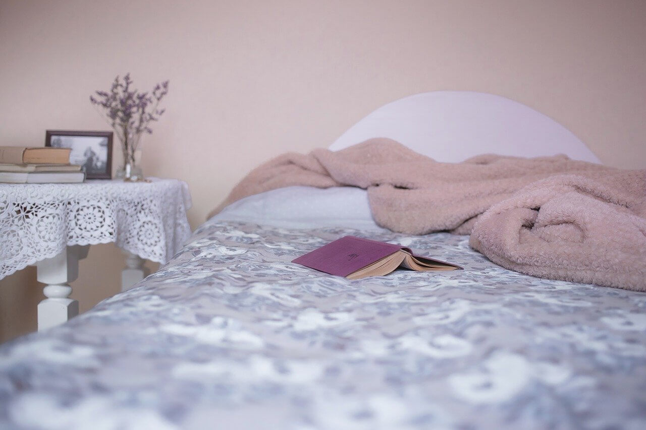 bed with sheets and a blanket