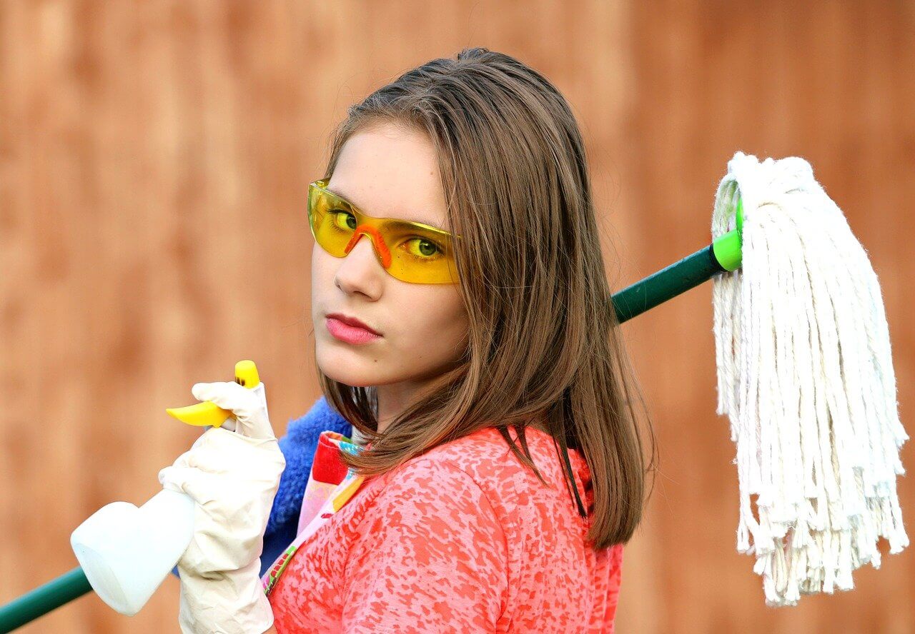 girl holding a squirt bottle and mop