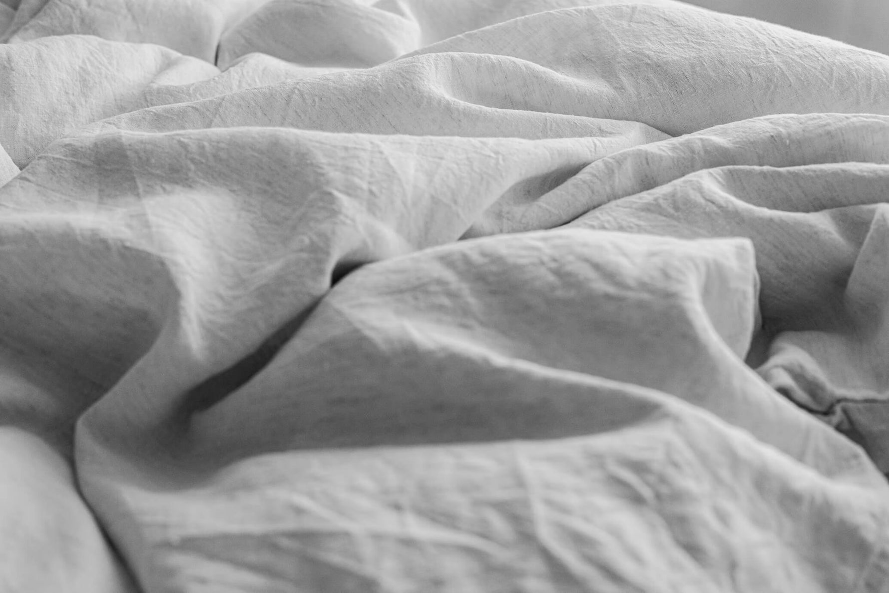 Rumpled gray sheets on a bed
