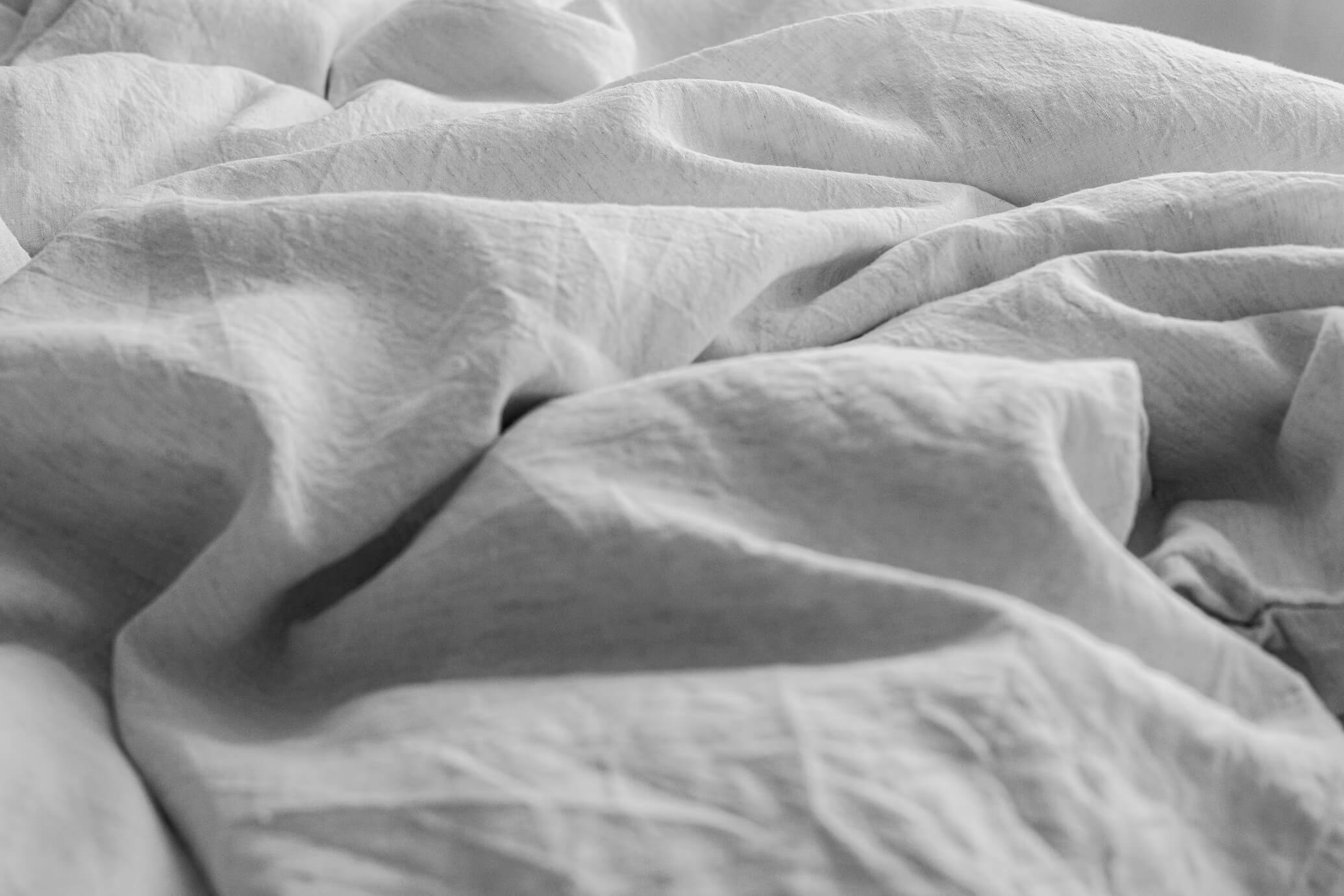 Rumpled gray sheets on a bed