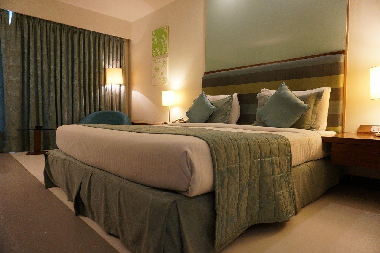 bed with green and tan bedding trend of 2022
