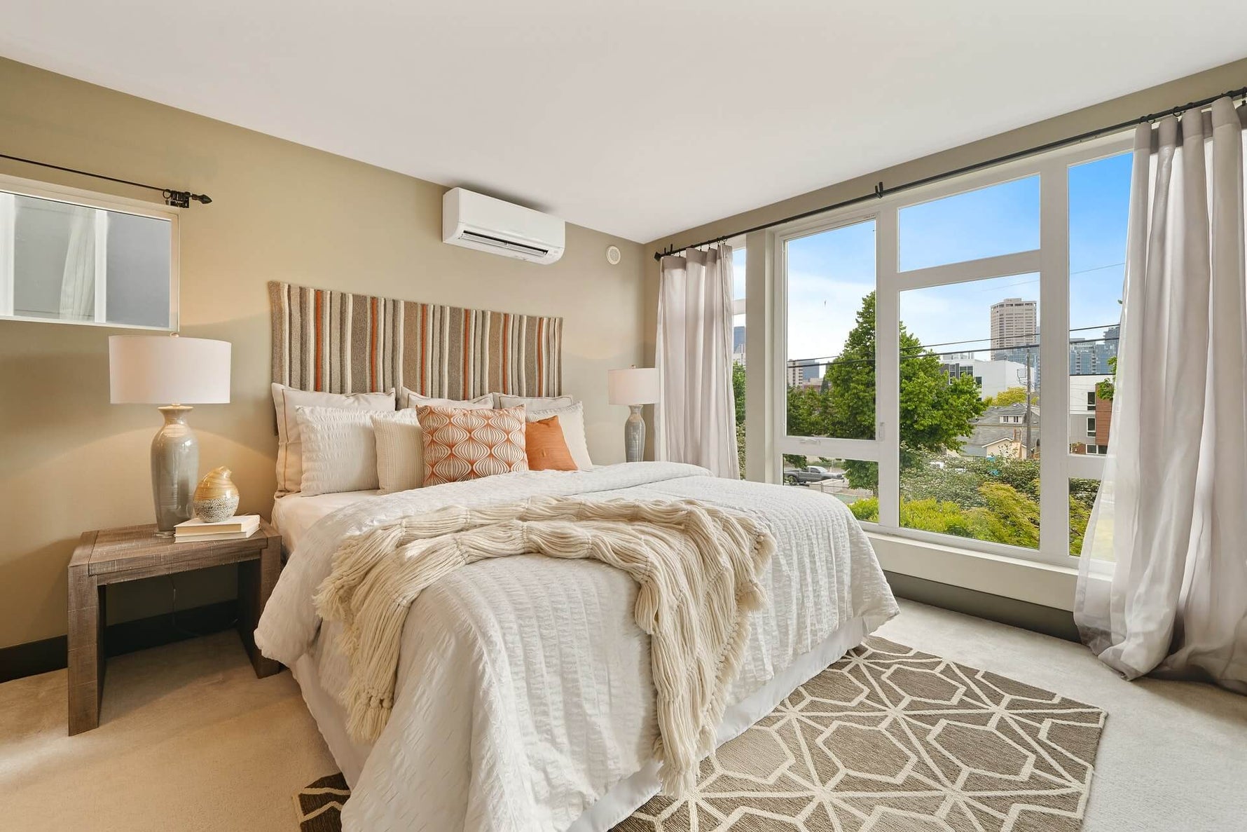 Bright summery bedroom with white bed set and large open windows
